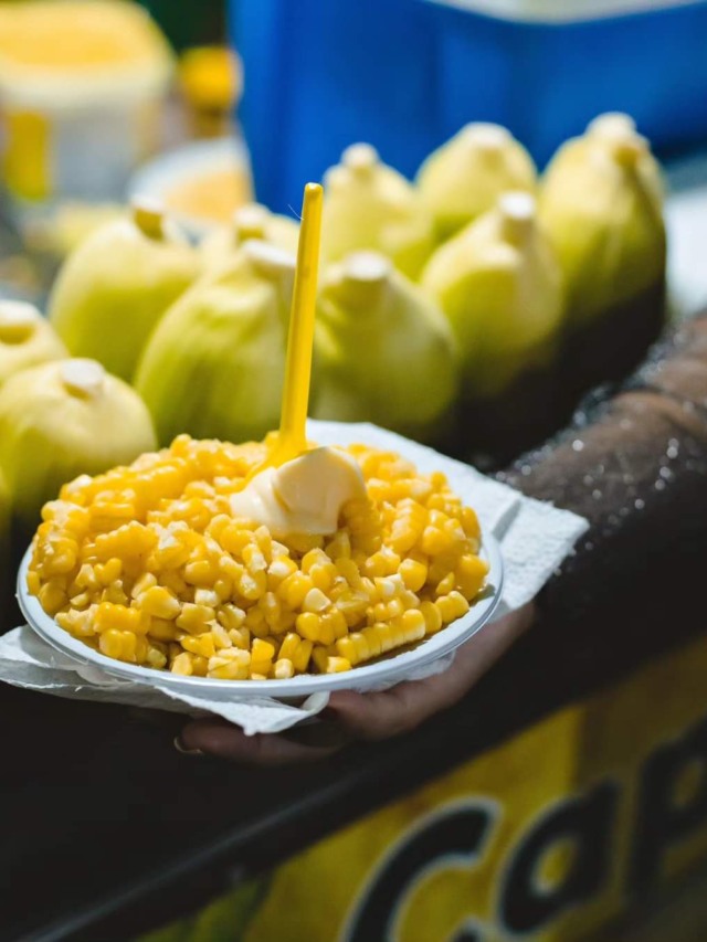 Pote de milho à frente e espigas em segundo plano
